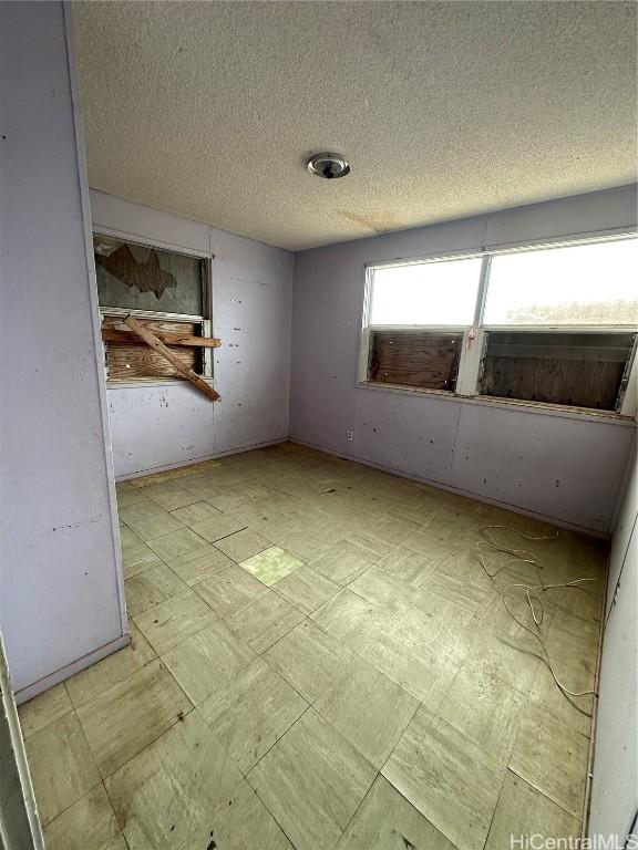 unfurnished room featuring a textured ceiling