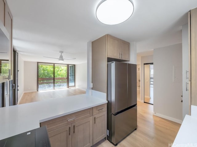 kitchen with light hardwood / wood-style floors, stainless steel refrigerator, and ceiling fan