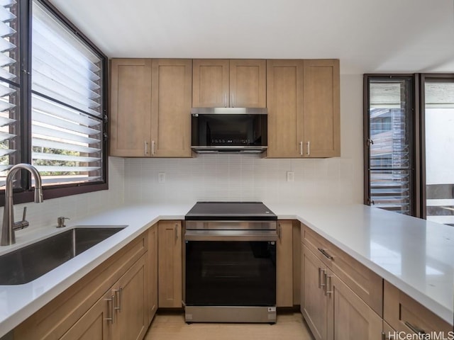 kitchen with tasteful backsplash, sink, and appliances with stainless steel finishes