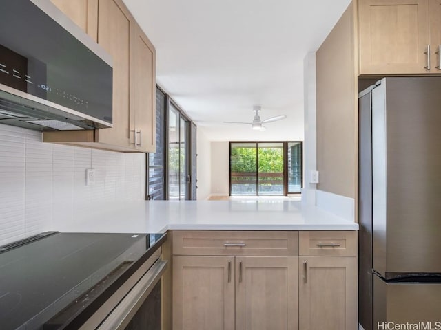 kitchen with ceiling fan, tasteful backsplash, kitchen peninsula, light brown cabinetry, and appliances with stainless steel finishes