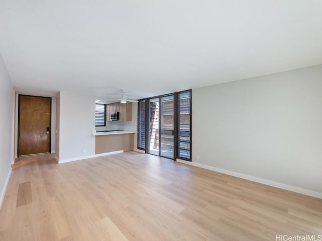 unfurnished living room with ceiling fan and light wood-type flooring