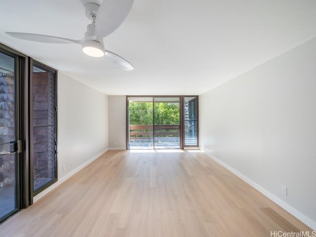 unfurnished room with light hardwood / wood-style floors, floor to ceiling windows, and ceiling fan