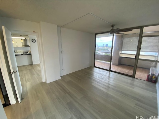 interior space featuring light hardwood / wood-style floors, expansive windows, and ceiling fan