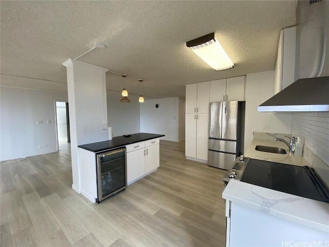 kitchen with stainless steel fridge, white cabinetry, wine cooler, and exhaust hood