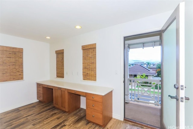 office featuring built in desk and dark hardwood / wood-style floors