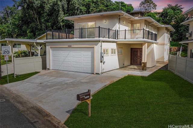 view of front of home featuring a lawn, a balcony, and a garage