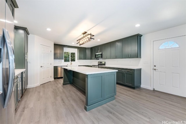 kitchen with a center island, light wood-type flooring, sink, and appliances with stainless steel finishes