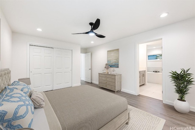 bedroom with connected bathroom, ceiling fan, a closet, and hardwood / wood-style flooring