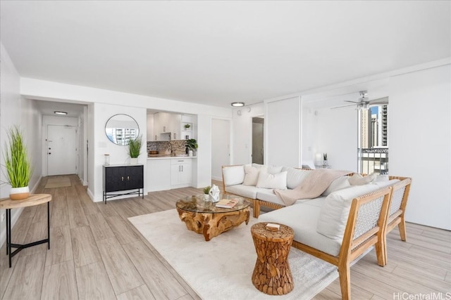 living room with ceiling fan and light hardwood / wood-style flooring