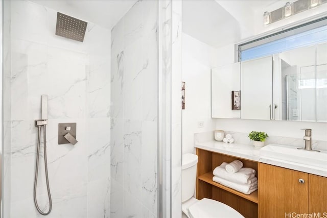 bathroom with vanity, toilet, and tiled shower