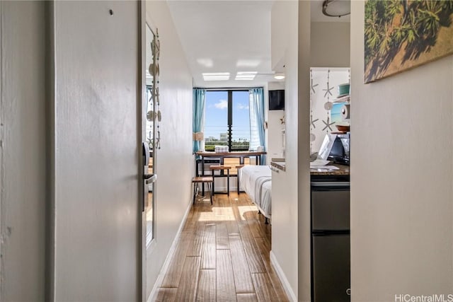 hallway featuring hardwood / wood-style floors and a wall of windows