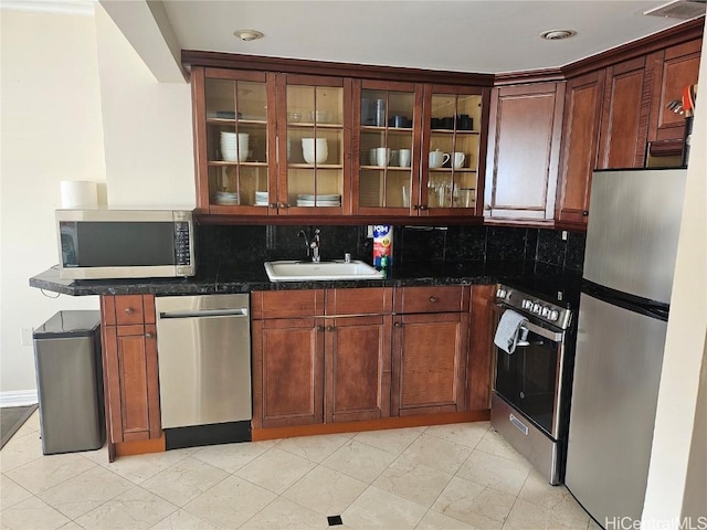 kitchen with backsplash, sink, stainless steel appliances, and dark stone counters