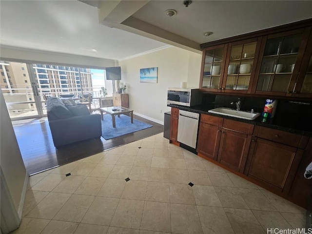 kitchen featuring sink, light tile patterned floors, stainless steel appliances, and ornamental molding