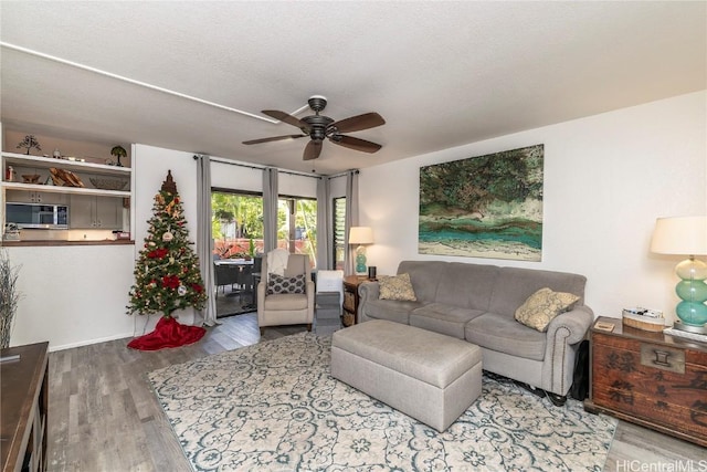 living room with a textured ceiling, light hardwood / wood-style floors, and ceiling fan