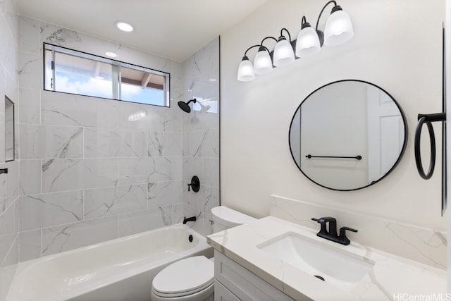 full bathroom featuring vanity, tiled shower / bath combo, and toilet