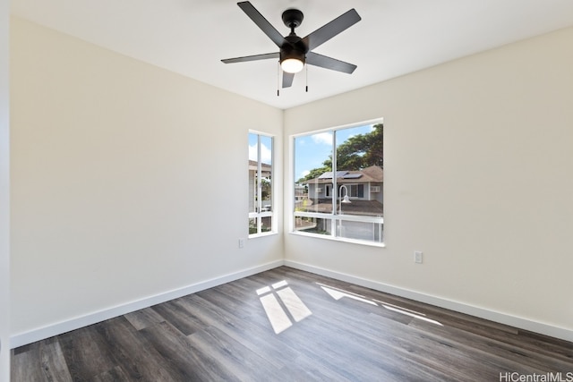 empty room with ceiling fan and dark hardwood / wood-style flooring