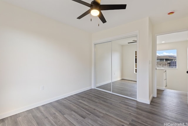 unfurnished bedroom with hardwood / wood-style floors, a closet, and ceiling fan