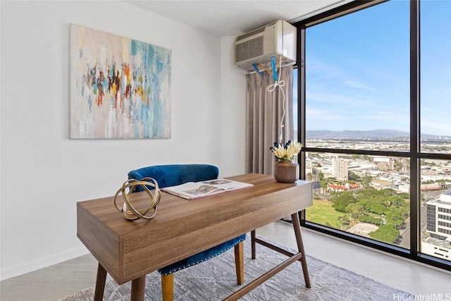 office space with expansive windows and an AC wall unit