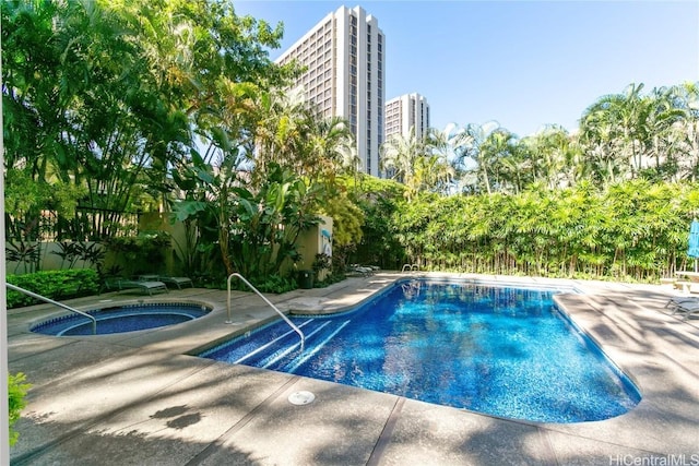 view of swimming pool featuring an in ground hot tub