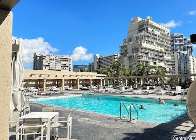 community pool with a patio and a city view