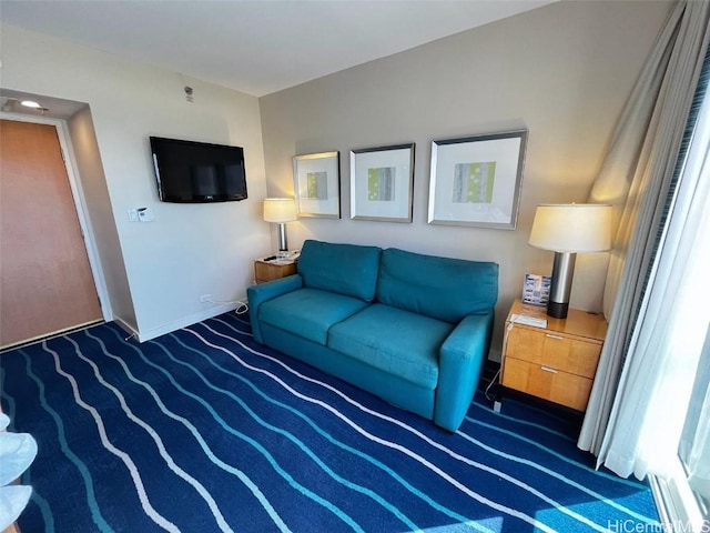 living area with dark colored carpet and baseboards