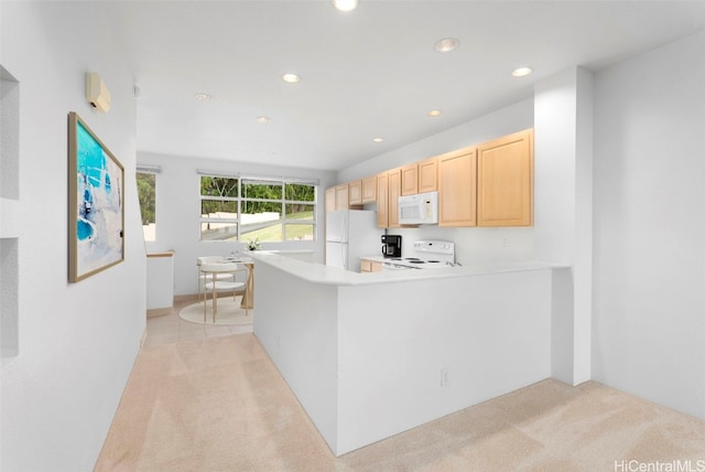 kitchen with light brown cabinets, white appliances, kitchen peninsula, and light carpet