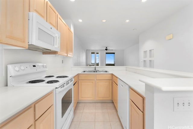 kitchen featuring kitchen peninsula, light brown cabinetry, white appliances, and sink