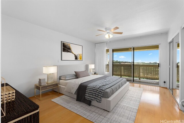 bedroom with access to exterior, light wood-type flooring, and ceiling fan