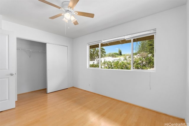 unfurnished bedroom featuring ceiling fan, light wood-type flooring, and a closet