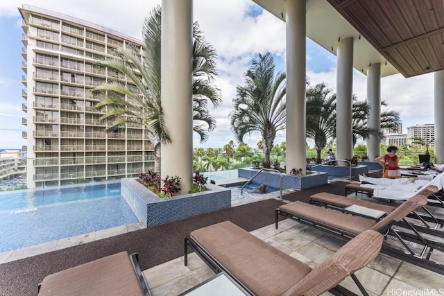 view of swimming pool featuring pool water feature and a patio