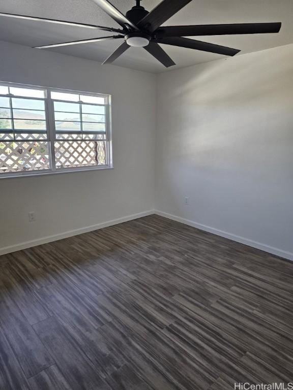 empty room featuring ceiling fan and dark wood-type flooring