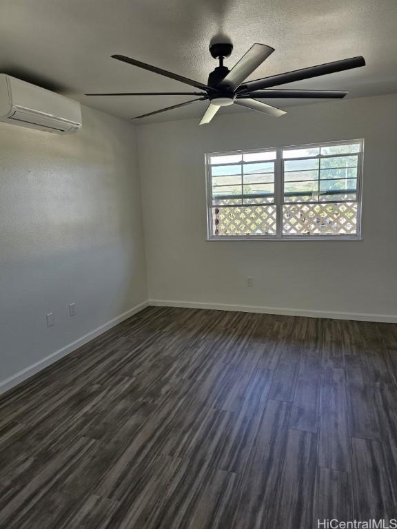 unfurnished room with dark hardwood / wood-style flooring and an AC wall unit