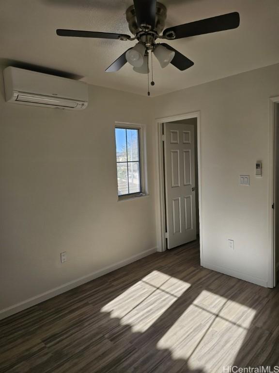 unfurnished bedroom with dark hardwood / wood-style flooring, a closet, a wall mounted AC, and ceiling fan