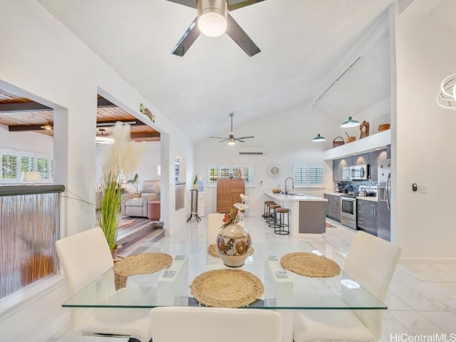 dining area with ceiling fan, sink, a wealth of natural light, and vaulted ceiling