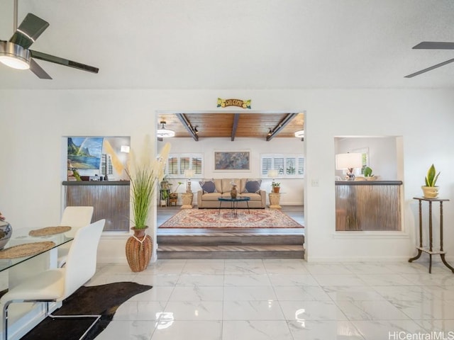 living room featuring ceiling fan, beamed ceiling, and wooden ceiling