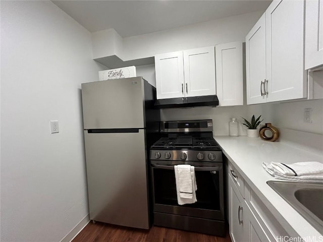 kitchen with appliances with stainless steel finishes, dark hardwood / wood-style floors, white cabinetry, and sink