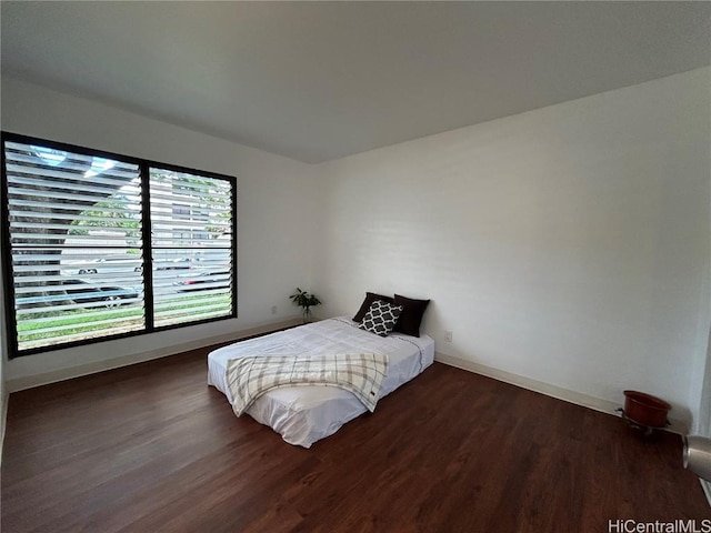 bedroom with dark hardwood / wood-style floors and multiple windows