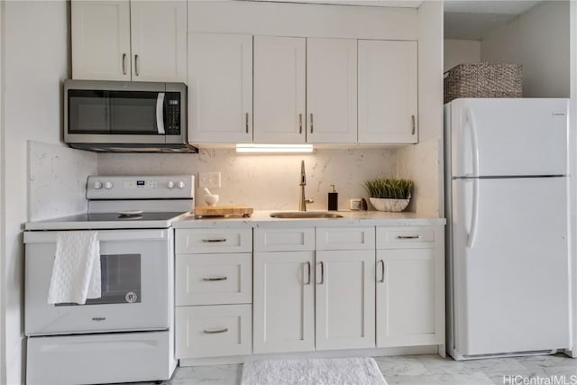 kitchen with decorative backsplash, sink, white cabinets, and white appliances