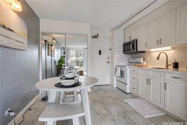 kitchen featuring white cabinetry, decorative backsplash, white electric stove, light stone counters, and sink