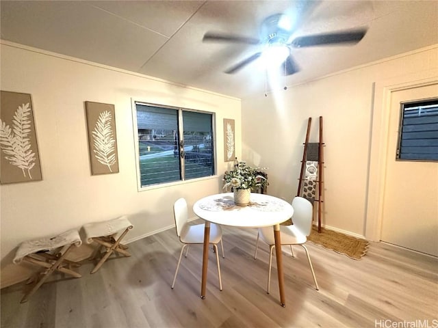 dining area featuring light wood-style floors, baseboards, and a ceiling fan