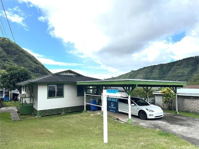 exterior space with a mountain view and a front lawn