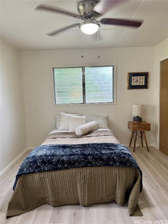 bedroom with ceiling fan, baseboards, and wood finished floors