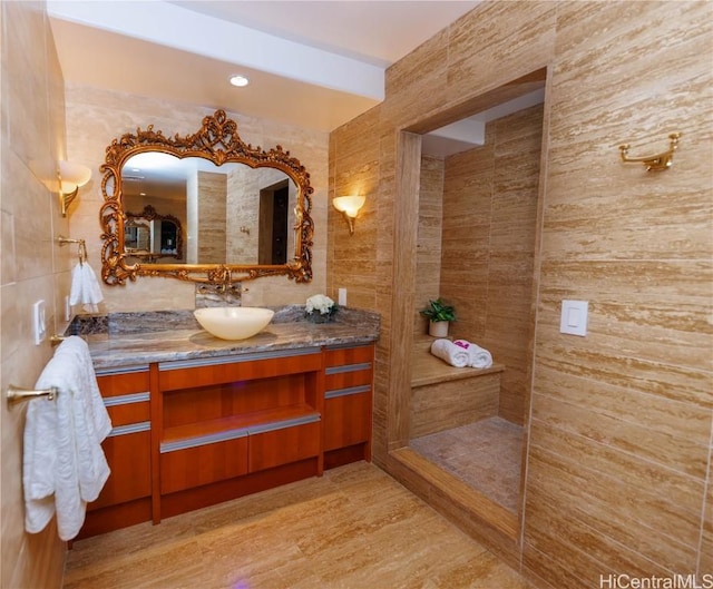 bathroom with vanity and tile walls