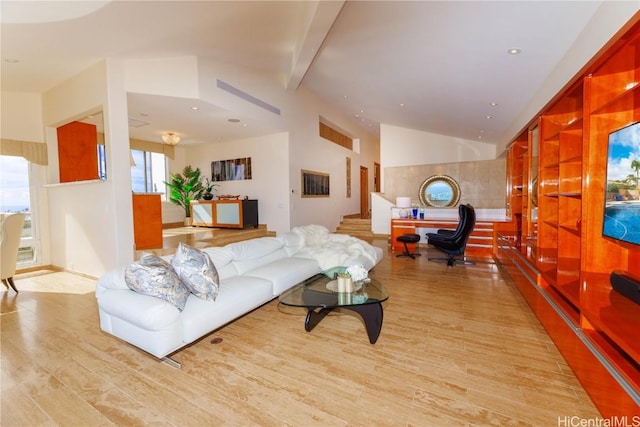 living room featuring vaulted ceiling with beams and light hardwood / wood-style flooring