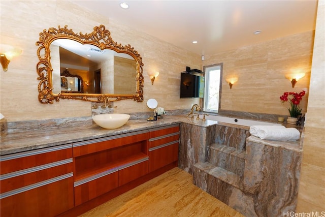 bathroom featuring vanity, tile walls, and a bathing tub