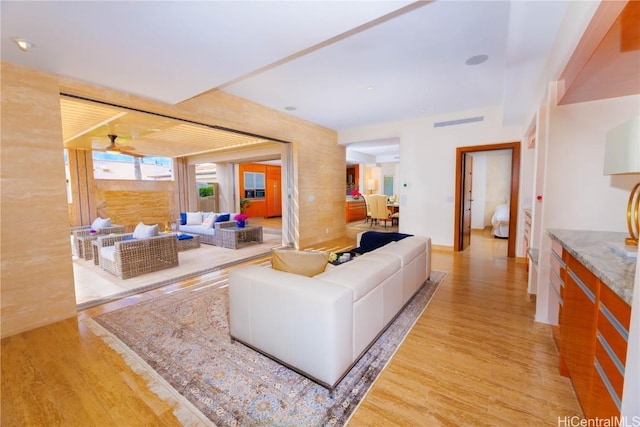 living room featuring light hardwood / wood-style flooring and ceiling fan