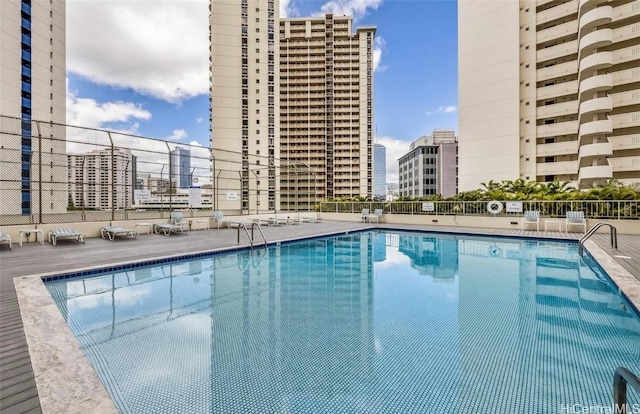 community pool with a view of city and fence