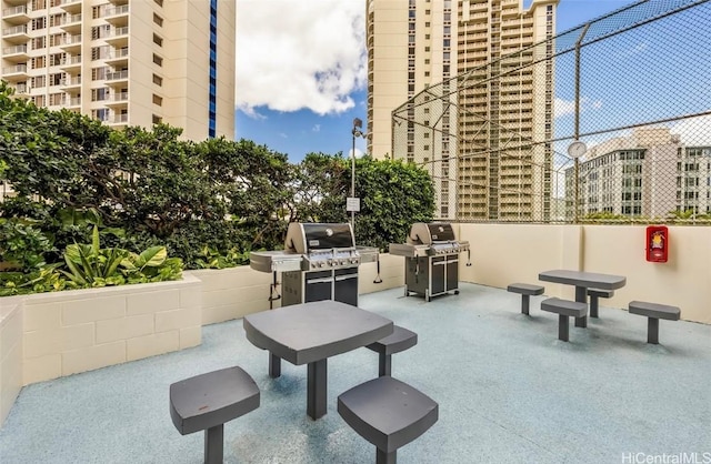 view of patio with area for grilling and a city view