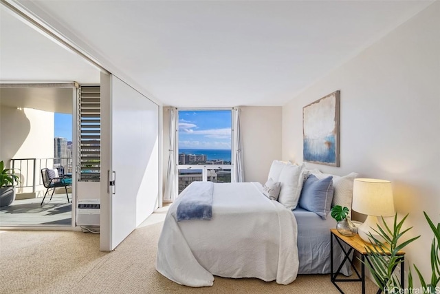 carpeted bedroom featuring a wall of windows and access to outside