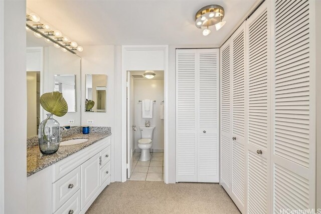 bathroom with vanity, tile patterned flooring, and toilet